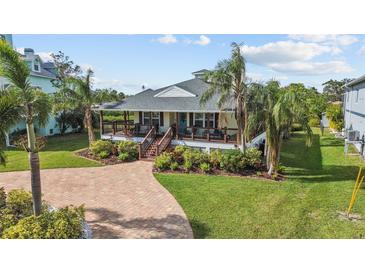 Single-story home with a large front porch, landscaping, and brick driveway at 505 Sally Lee Dr, Ellenton, FL 34222