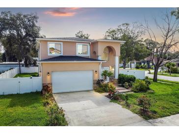 Two-story house with attached garage, landscaping, and a white fence at 8115 61St N St, Pinellas Park, FL 33781