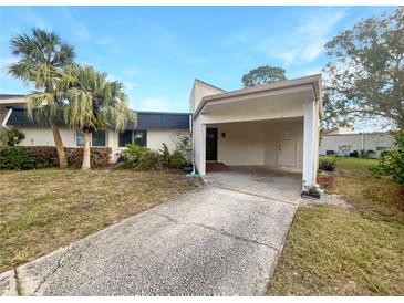 Exterior view of condo with carport and landscaped yard at 2587 Forest Run Ct # 141B, Clearwater, FL 33761