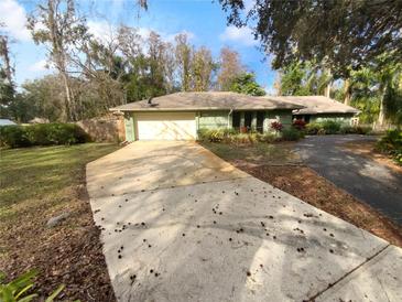 Ranch style home with a large driveway and mature landscaping at 6826 San Jose Loop, New Port Richey, FL 34655