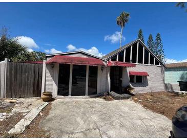 A charming one-story home with a red awning and a spacious yard at 16211 3Rd E St, Redington Beach, FL 33708