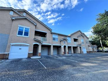 Tan colored building exterior with white garage doors and parking lot at 10412 Villa View Cir, Tampa, FL 33647