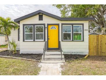 Newly renovated home with a yellow door and modern landscaping at 1502 10Th W St, Bradenton, FL 34205