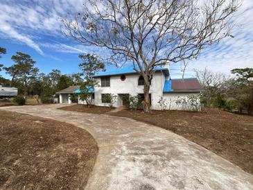 Two-story house with blue roof and a long driveway at 37921 Tiffany Rd, Dade City, FL 33525