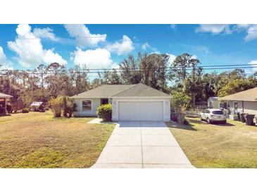 Single-story home with a driveway and a grassy lawn at 2315 Snowflake Ln, North Port, FL 34286