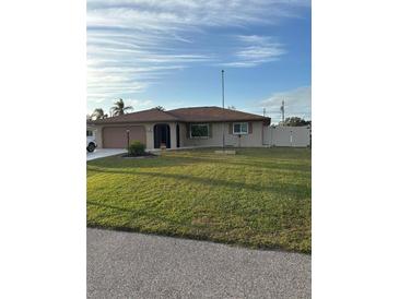 Single-story home with a well-manicured lawn and attached garage at 1000 Osceola Blvd, Englewood, FL 34223