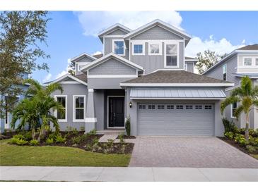 Two-story home with gray siding, a three-car garage, and landscaping at 1003 Signet Dr, Apollo Beach, FL 33572