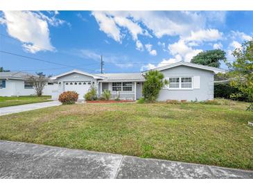 Ranch style home with a well-maintained lawn and attached garage at 11095 56Th N Ave, Seminole, FL 33772