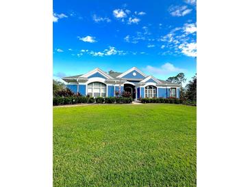 Stunning blue house with white accents, lush lawn, and mature landscaping at 13655 N Branch Rd, Sarasota, FL 34240