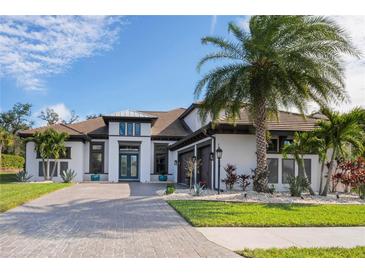 White two-story house with brown roof, palm trees, and a paved driveway at 9044 Luna Ln, Sarasota, FL 34241