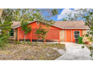 Bright orange house with covered patio and landscaped yard at 70 Horton Cir, Sarasota, FL 34232