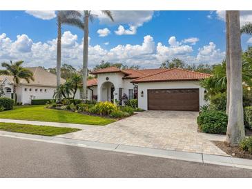 Single-story home with brown garage door, landscaped yard, and tile driveway at 6720 The Masters Ave, Lakewood Ranch, FL 34202