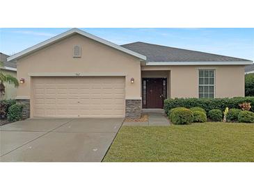 Tan one-story house with a two-car garage and landscaped lawn at 562 Vista Ridge Dr, Ruskin, FL 33570
