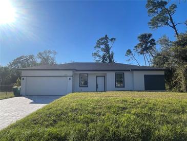 Newly constructed one-story home with a white exterior, gray accents, and a neatly landscaped lawn at 1401 Newton St, Port Charlotte, FL 33952