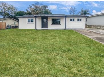Newly renovated house with a large front yard and driveway at 9640 Mark Twain Ln, Port Richey, FL 34668