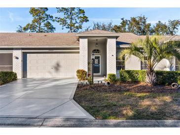 Brick front exterior of home with attached garage and landscaping at 18004 Tarrington Pl, Hudson, FL 34667