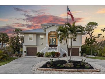 Two-story house with attached garage and palm trees in the front yard at 7092 Baypine Ln, Englewood, FL 34224