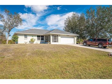 Single-story home with attached garage and spacious lawn at 27164 Citrus Ave, Punta Gorda, FL 33983