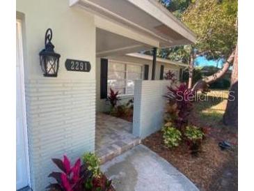 Inviting house exterior with a landscaped walkway leading to the entrance at 2291 Claiborne Dr, Clearwater, FL 33764