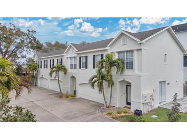 Three-unit building exterior, featuring attached garages and palm trees at 2607 W Cleveland St # B, Tampa, FL 33609