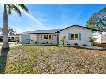 Charming single-story home featuring a well-maintained lawn and a light blue garage door at 105 12Th Sw St, Ruskin, FL 33570