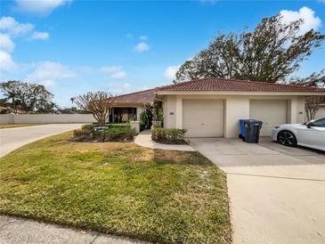 Charming home featuring a red tile roof, well-maintained landscaping, and an attached two-car garage at 18315 Aintree Ct, Tampa, FL 33647