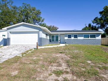 Charming single-story home with a two-car garage, gray paint, and well-maintained front lawn at 8549 Oakhurst Rd, Seminole, FL 33776