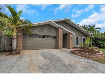 Charming single-story home features a two-car garage, lush landscaping, and a welcoming front entrance at 289 Whisper Lake Rd, Palm Harbor, FL 34683