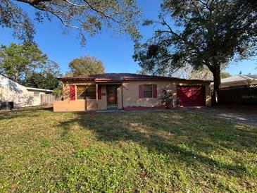 Charming single-story home with a metal roof, red shutters, and a well-maintained front lawn at 3923 W Bay View Ave, Tampa, FL 33611