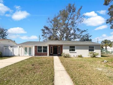 Charming single-story home featuring a brick facade and well-manicured lawn, offering classic curb appeal at 4508 Golfwood Blvd, Tampa, FL 33634