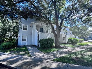 Inviting condo exterior with mature trees, sidewalks, and well-maintained landscaping at 7177 E Bank Dr # 102, Tampa, FL 33617