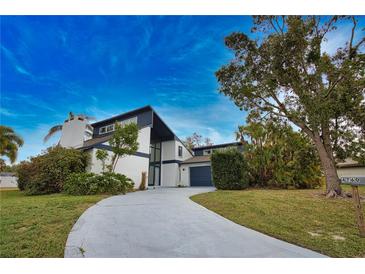 Charming two-story home with a well-manicured lawn, mature trees, and a long private driveway at 4760 Meredith Ln, Sarasota, FL 34241