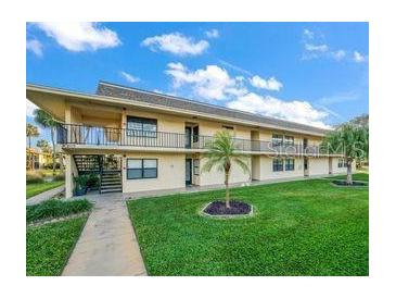 Two-story condo building with mature landscaping and exterior staircases to the second floor units at 12300 Vonn Rd # 7203, Largo, FL 33774