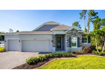 Beautiful single-story home featuring stone accents, manicured landscaping, and a spacious three-car garage at 25172 Calusa Dr, Punta Gorda, FL 33955