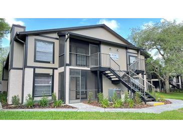 Inviting two-story condo featuring a screened patio and staircase access, offering a blend of comfort and outdoor enjoyment at 4034 Dream Oak Pl # 104, Tampa, FL 33613