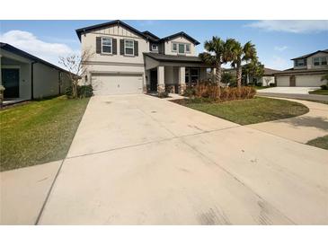 Charming two-story home with a well-manicured front lawn and a spacious driveway leading to a two-car garage at 6525 Dutton Dr, Wesley Chapel, FL 33545