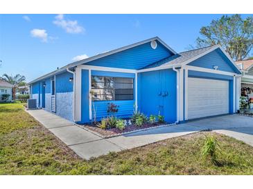 Charming blue home featuring a well-kept lawn and a two-car garage at 4522 Marine Pkwy, New Port Richey, FL 34652