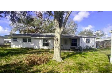 The backyard of the house is spacious and has a tree in the middle. There is also a covered patio at 1814 Elk Ave, Sarasota, FL 34235
