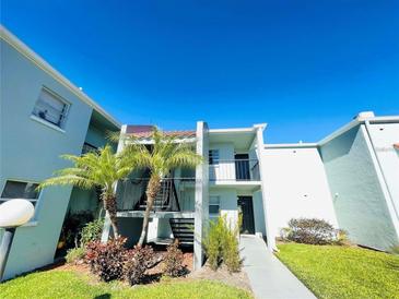 Two story condo unit with palm trees and lush landscaping under a sunny blue sky at 2856 Somerset Park Dr # 102, Tampa, FL 33613