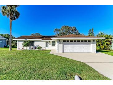 Charming single-story home featuring a well-manicured lawn, a two-car garage, and a freshly painted exterior at 408 43Rd Street W Blvd, Palmetto, FL 34221