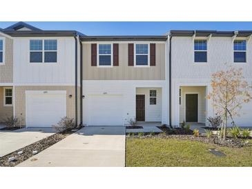 Charming townhomes featuring modern design, white garages, brown shutters and well-manicured lawns at 11840 Sylvia St, Dade City, FL 33525