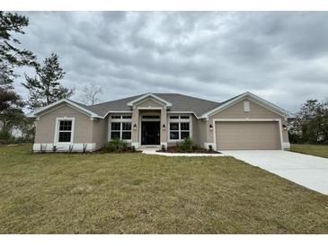 One-story home with a neutral color palette and a large yard at 5356 Frost Rd, Spring Hill, FL 34606