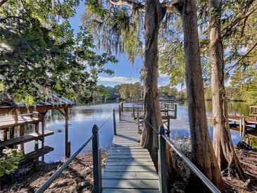 Relaxing lakefront deck with wooden planks and seating, offering serene waterfront views at 8531 Bass Lake Dr, New Port Richey, FL 34654