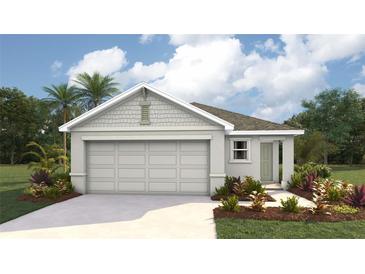 One-story home with light-gray siding, two-car garage, and landscaping at 30916 Wild Juniper Ct, Brooksville, FL 34602