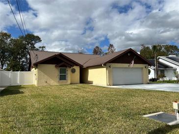 Tan brick single-Gathering home with brown metal roof, two-car garage, and a spacious lawn at 3619 Marco Dr, Tampa, FL 33614