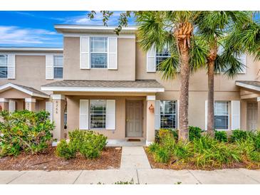 Tan two-story townhome with white shutters, a door, and landscaping at 6266 Triple Tail Ct # 103, Lakewood Ranch, FL 34202