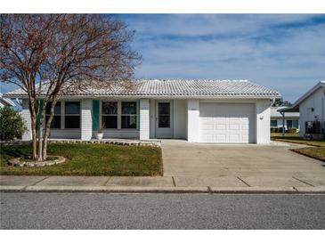 White single story home with teal shutters, attached garage, and landscaped lawn at 9205 40Th N Way # 5, Pinellas Park, FL 33782