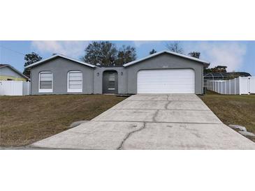 Gray house with white garage door and landscaping at 12117 Topaz St, Spring Hill, FL 34608