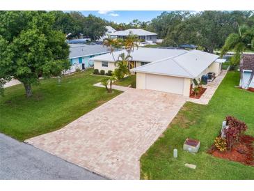 Aerial view of a single-story house with a large driveway and well-maintained lawn at 403 13Th Sw St, Ruskin, FL 33570