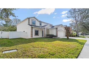 Two-story home with a well-manicured lawn and neutral paint at 5808 Falconcreek Pl, Lithia, FL 33547
